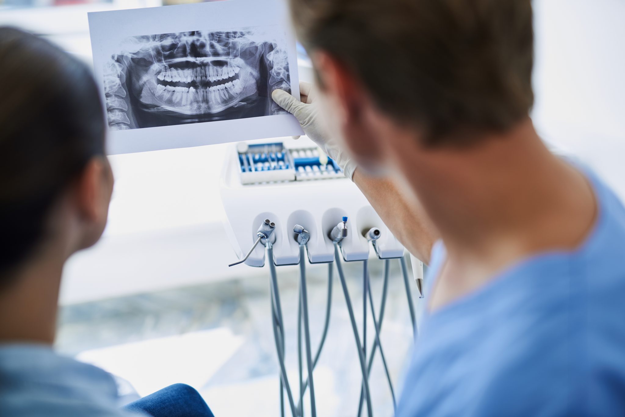 dentist showing results of orthopantomogram to young woman