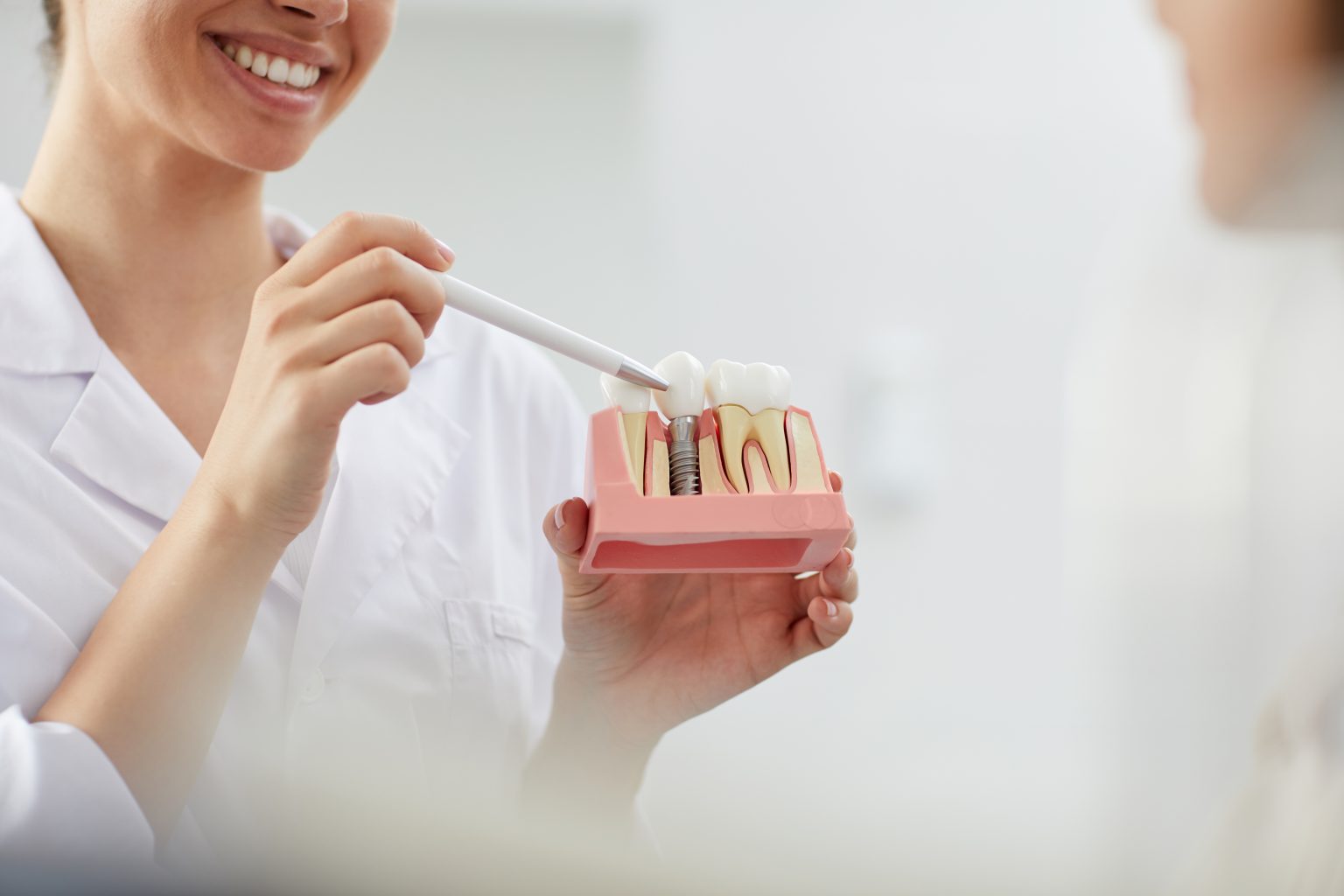 smiling dentist explaining tooth implantation