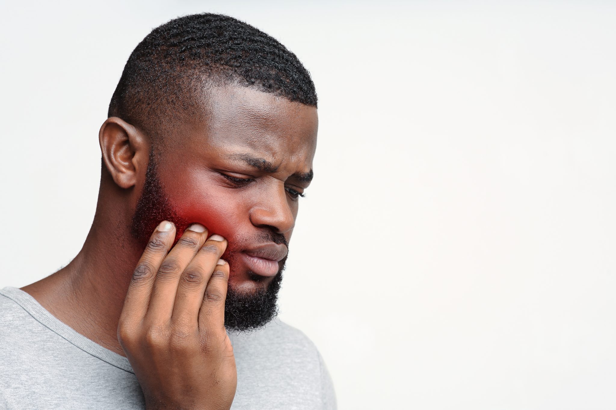 young sad man having pain in his teeth